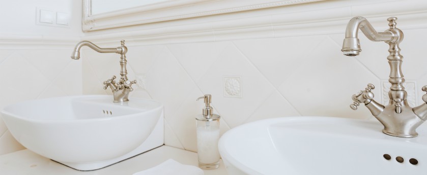 Bathroom with white ceramic sinks with vintage style faucets.